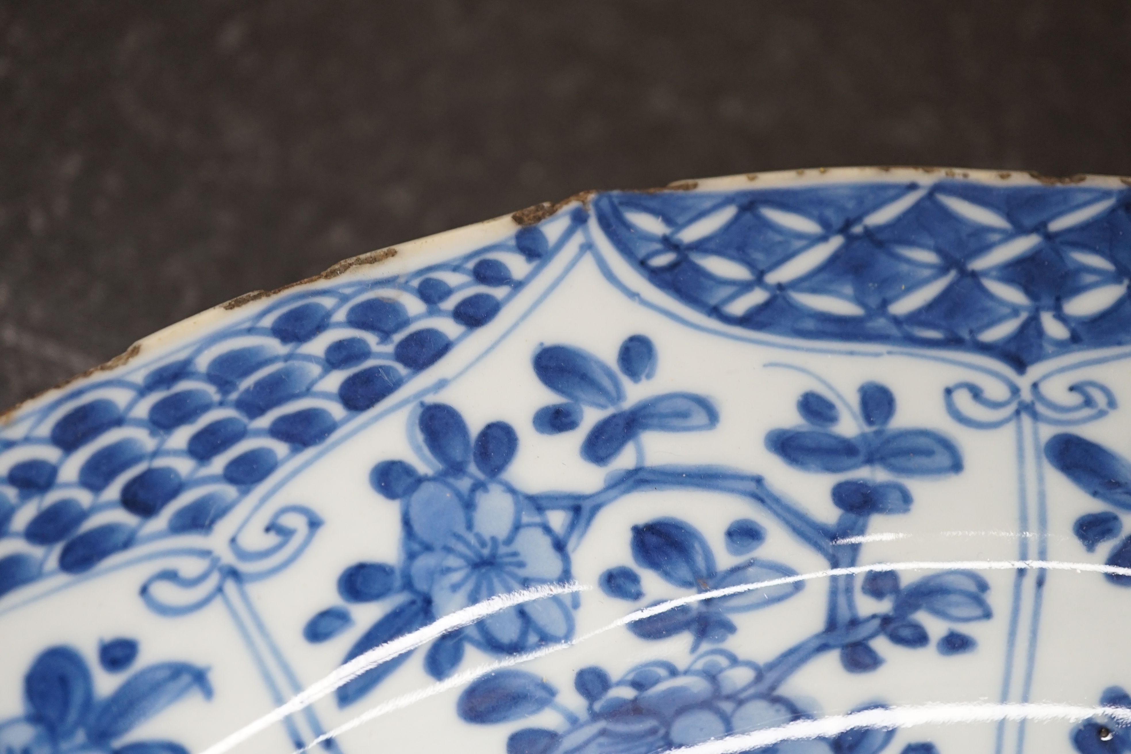 A pair of Chinese blue and white ‘garden’ dishes, Kangxi period, fritting and glaze chips